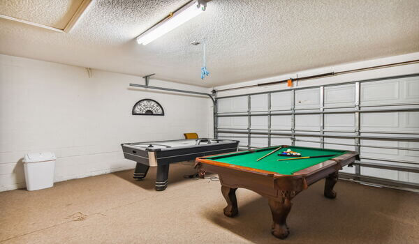Garage converted as a gameroom with a pool table and an air-hockey table