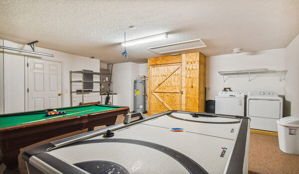 Garage converted as a gameroom with a pool table and an air-hockey table